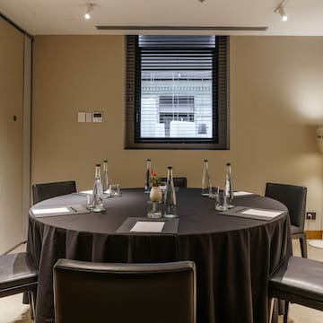 a round table with black tablecloth and chairs in a room