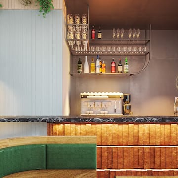 a bar with a shelf of wine glasses and a green couch
