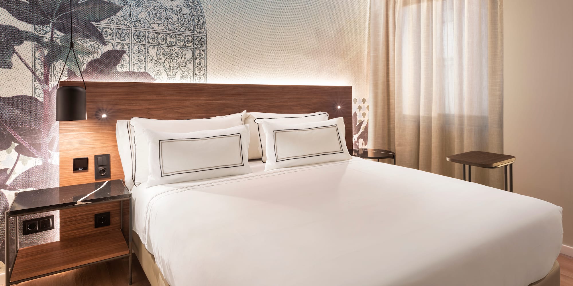 a bed with white sheets and a wood headboard