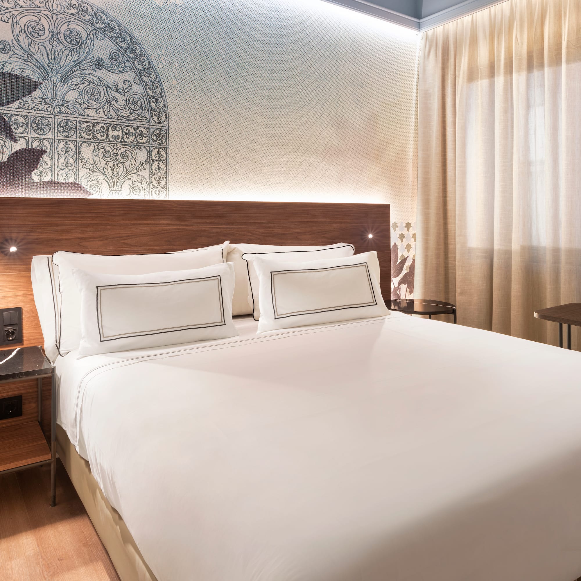 a bed with white sheets and a wood headboard