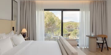 a bedroom with a bed and a table and chairs