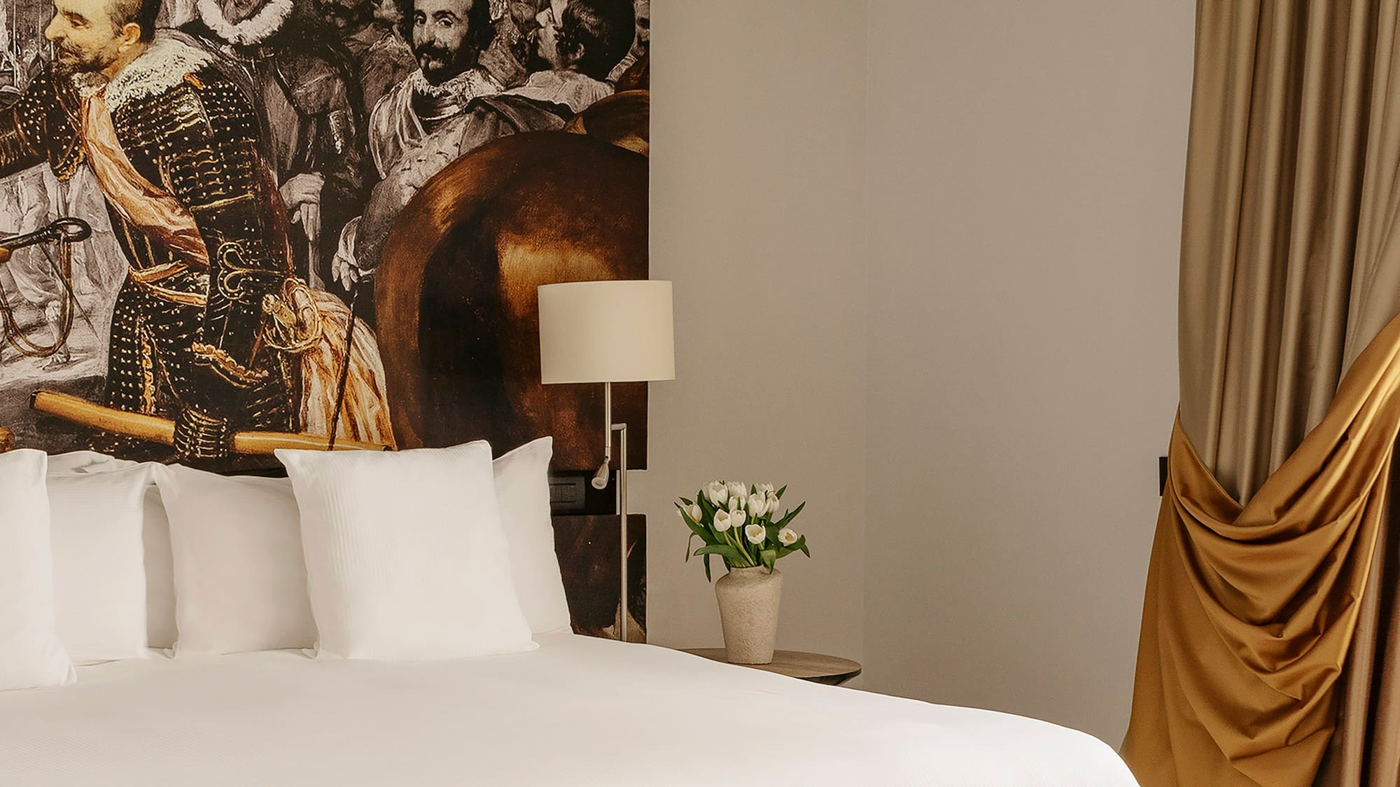 a bed with a picture of a man on the wall