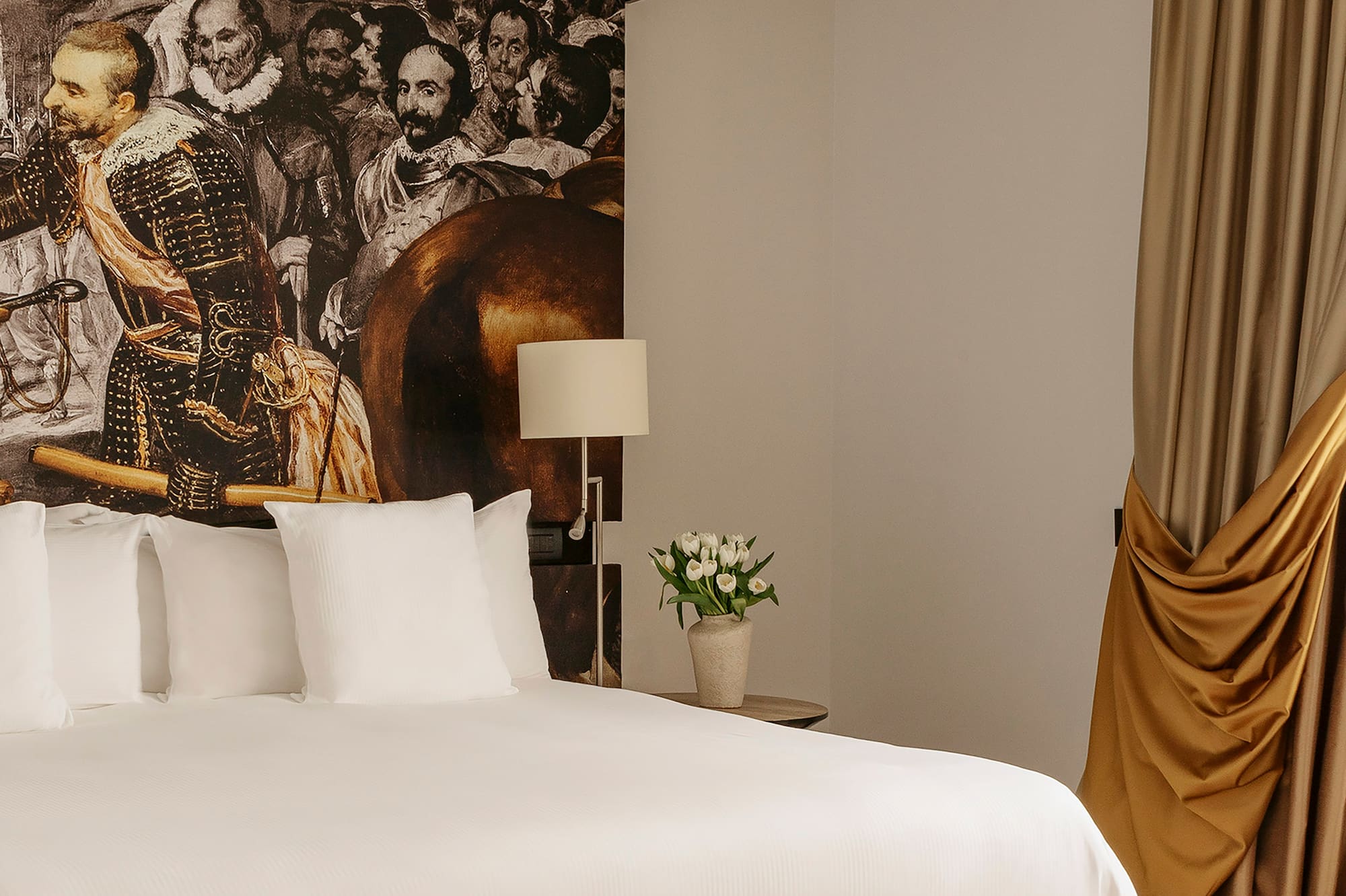 a bed with a picture of a man on the wall