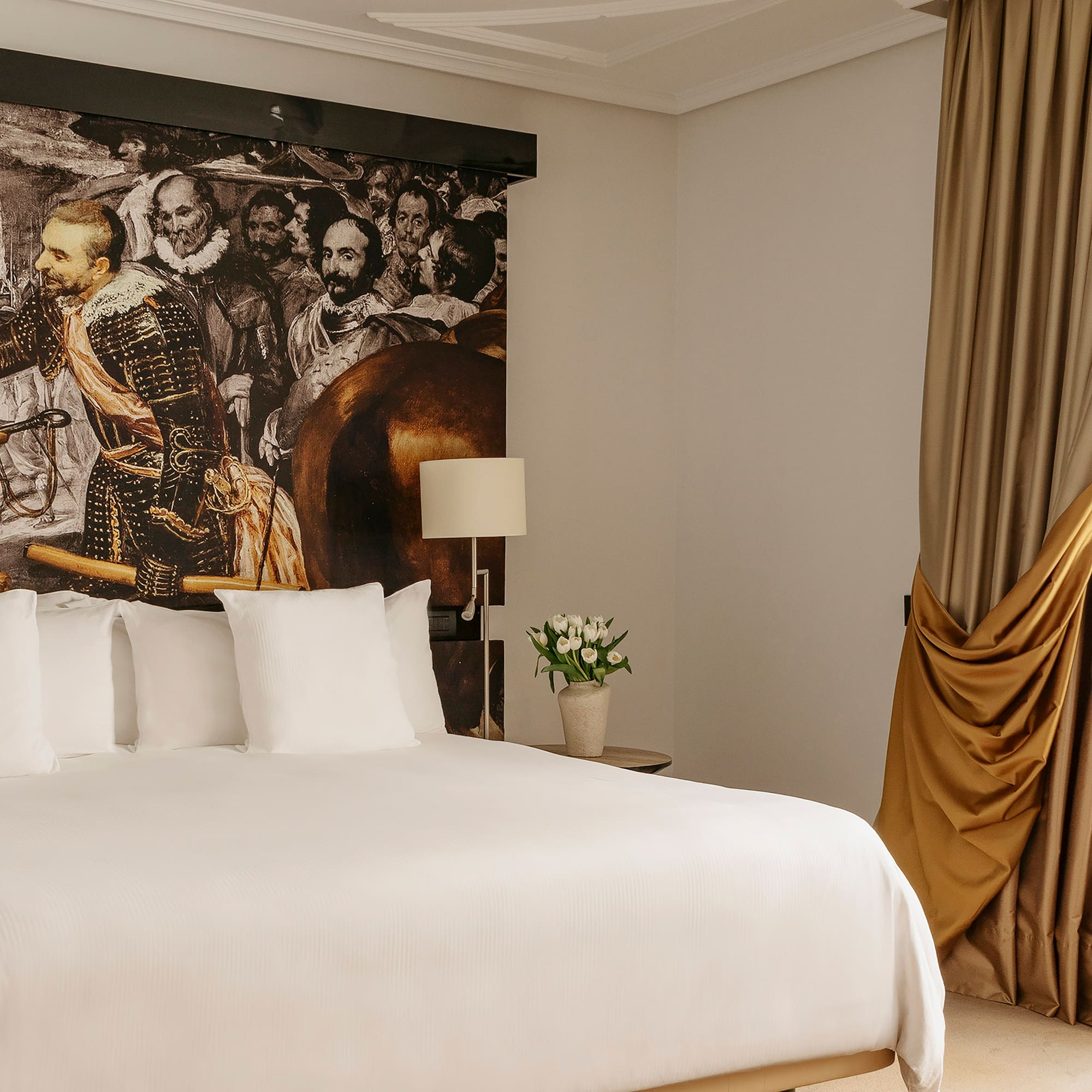 a bed with a picture of a man on the wall