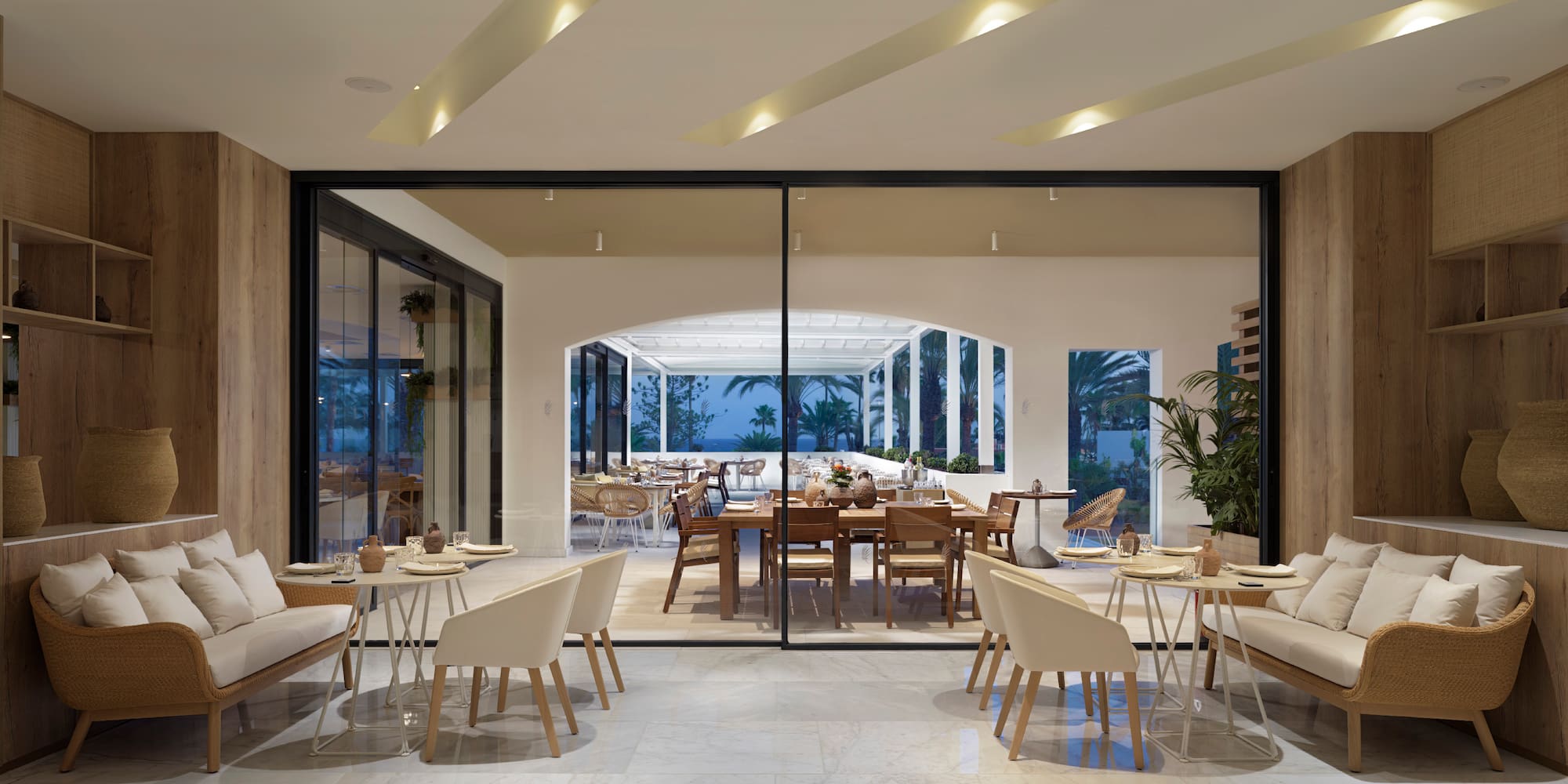 a room with a large glass wall and a table and chairs