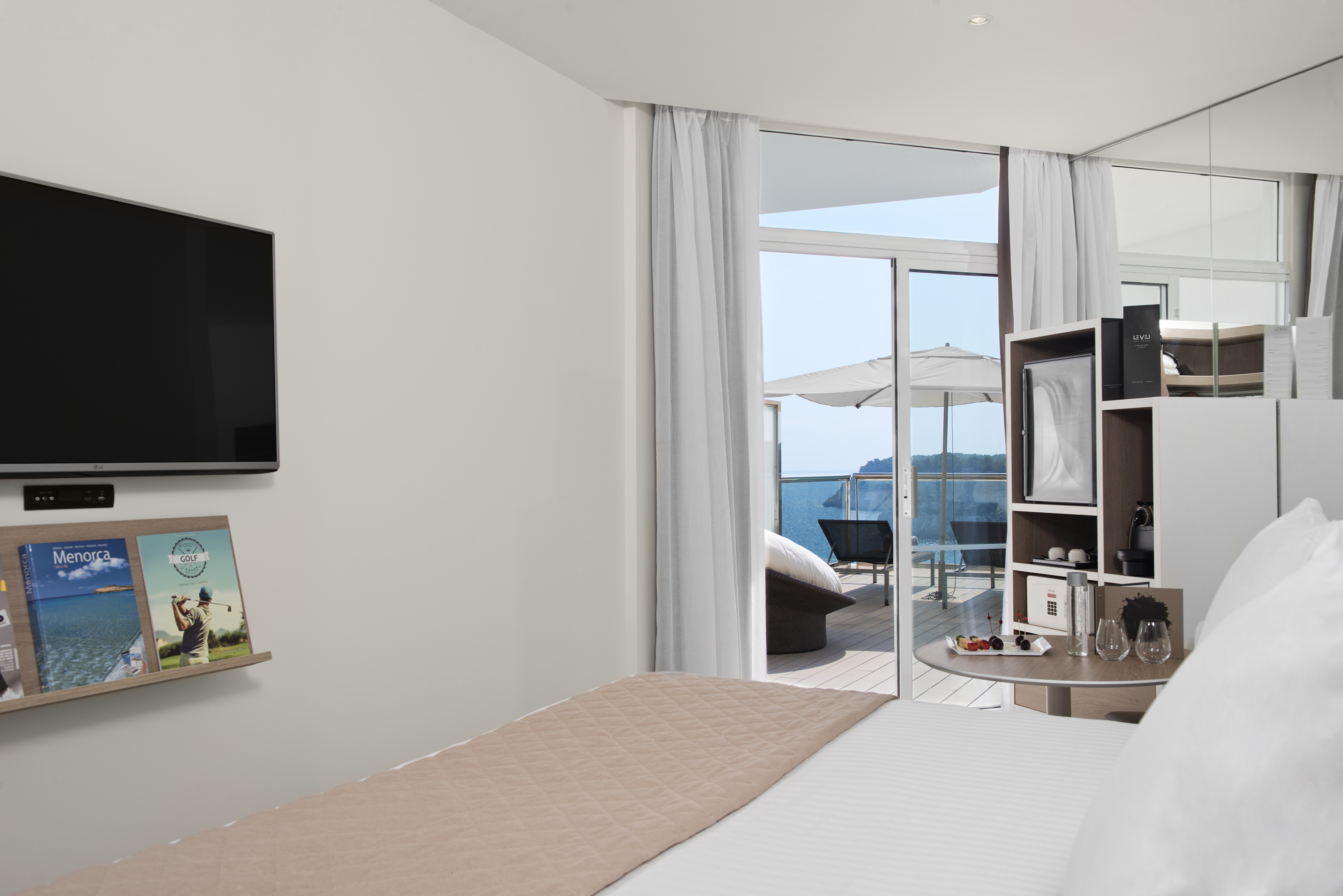 Luxury hotel room with private balcony, ocean view, and welcoming fruit.
