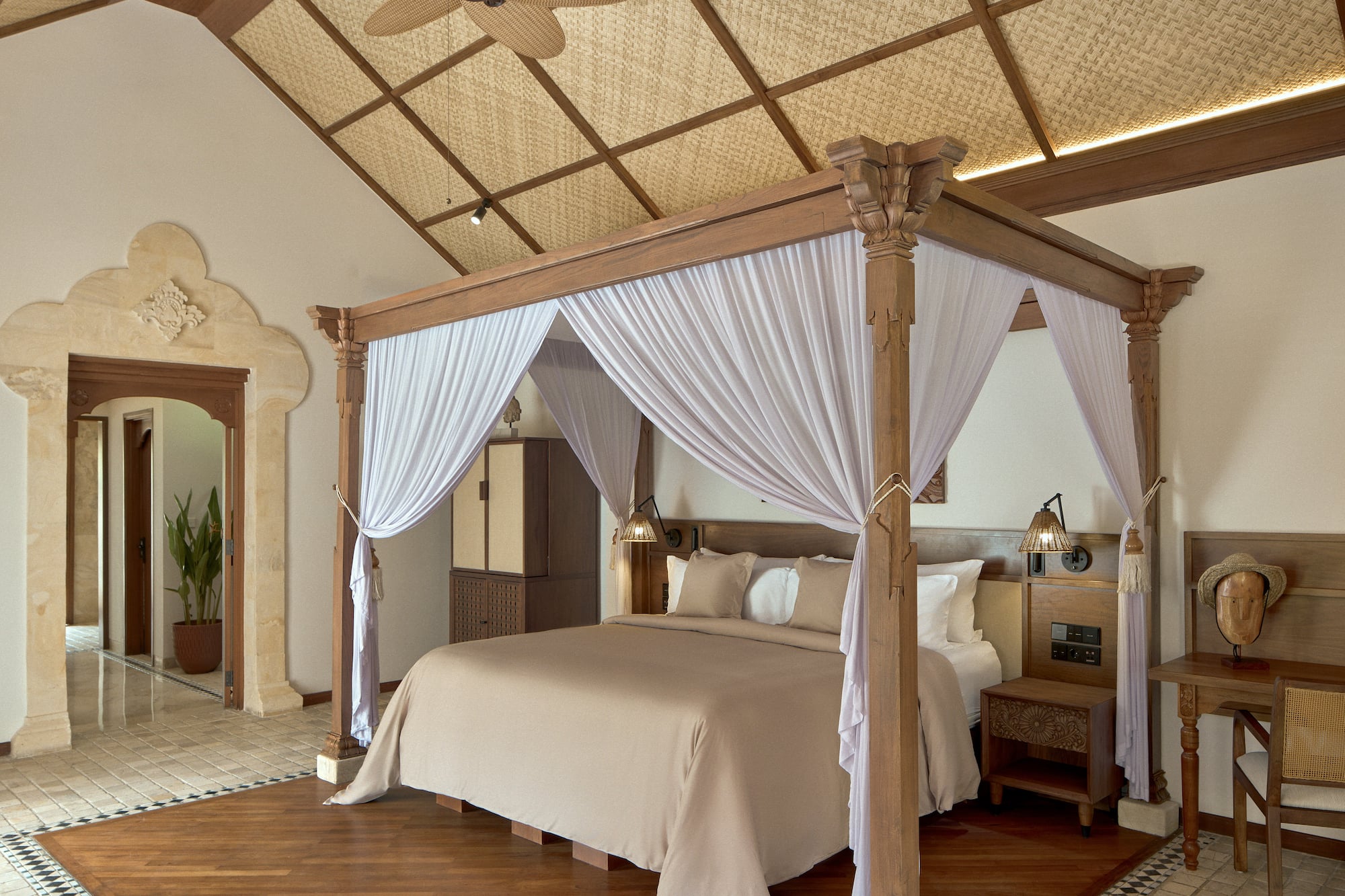 a bed with white curtains in a room