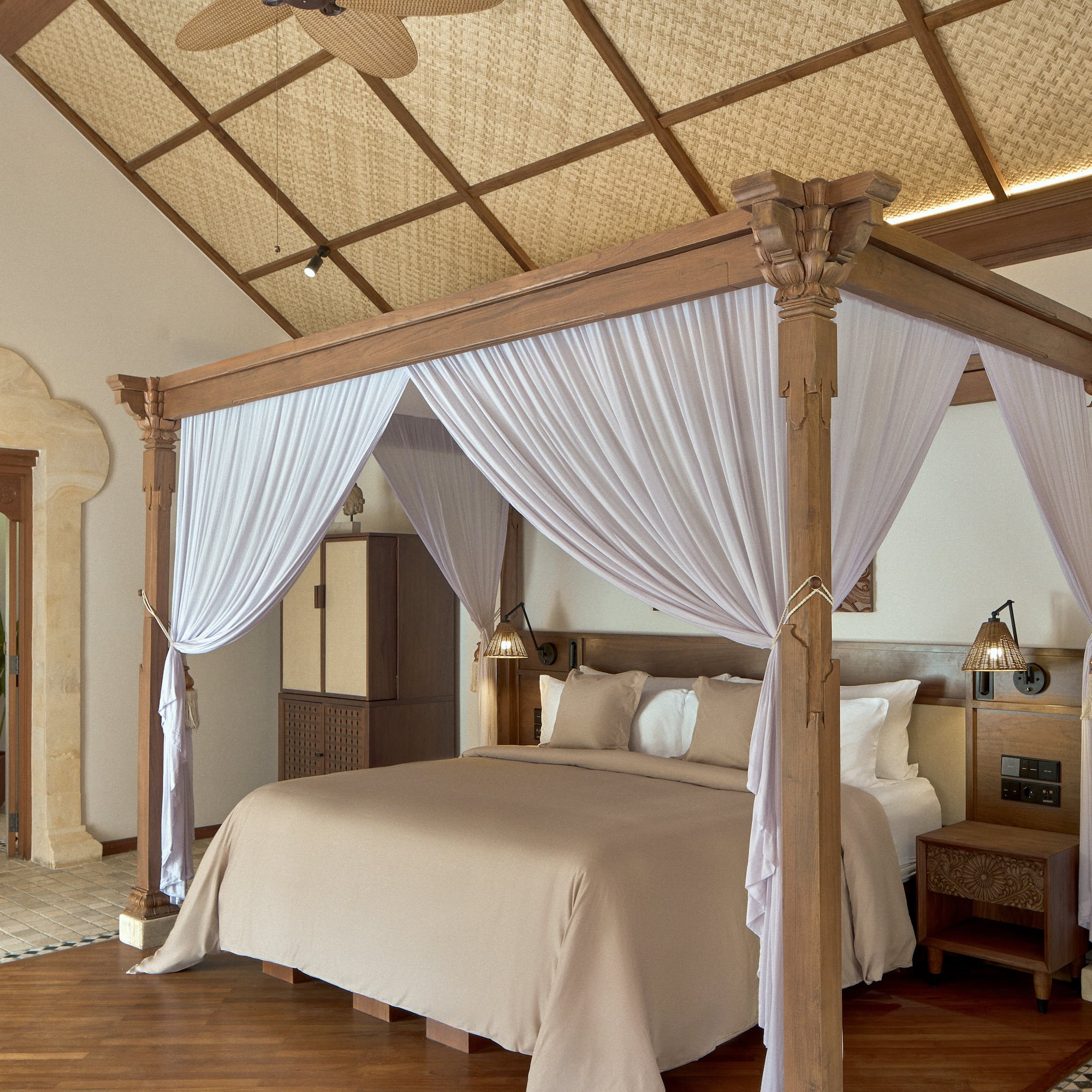 a bed with white curtains in a room