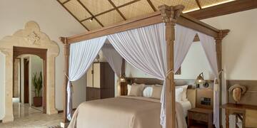 a bed with white curtains in a room