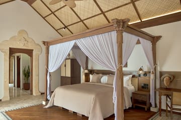 a bed with white curtains in a room