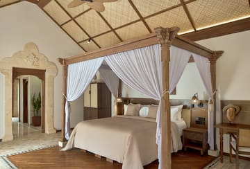 a bed with white curtains in a room