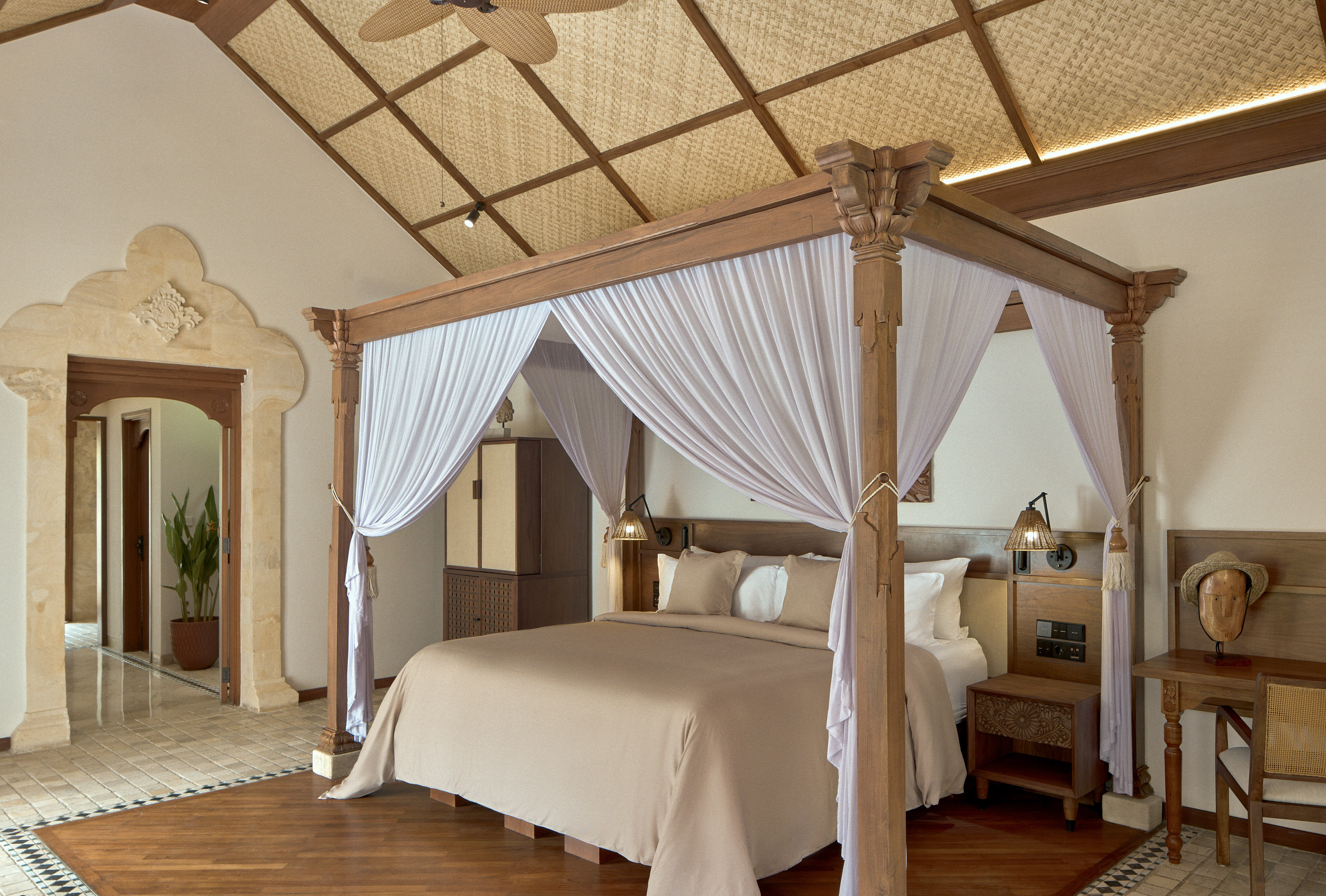 a bed with white curtains in a room