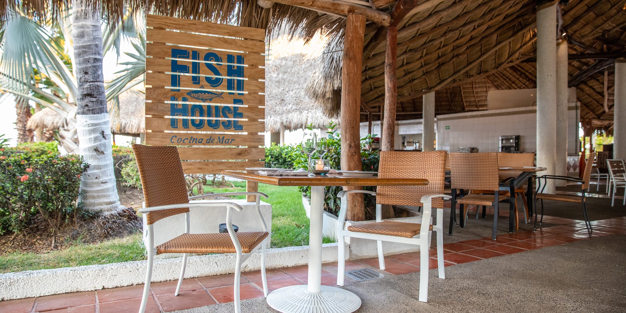 a table and chairs under a thatched roof