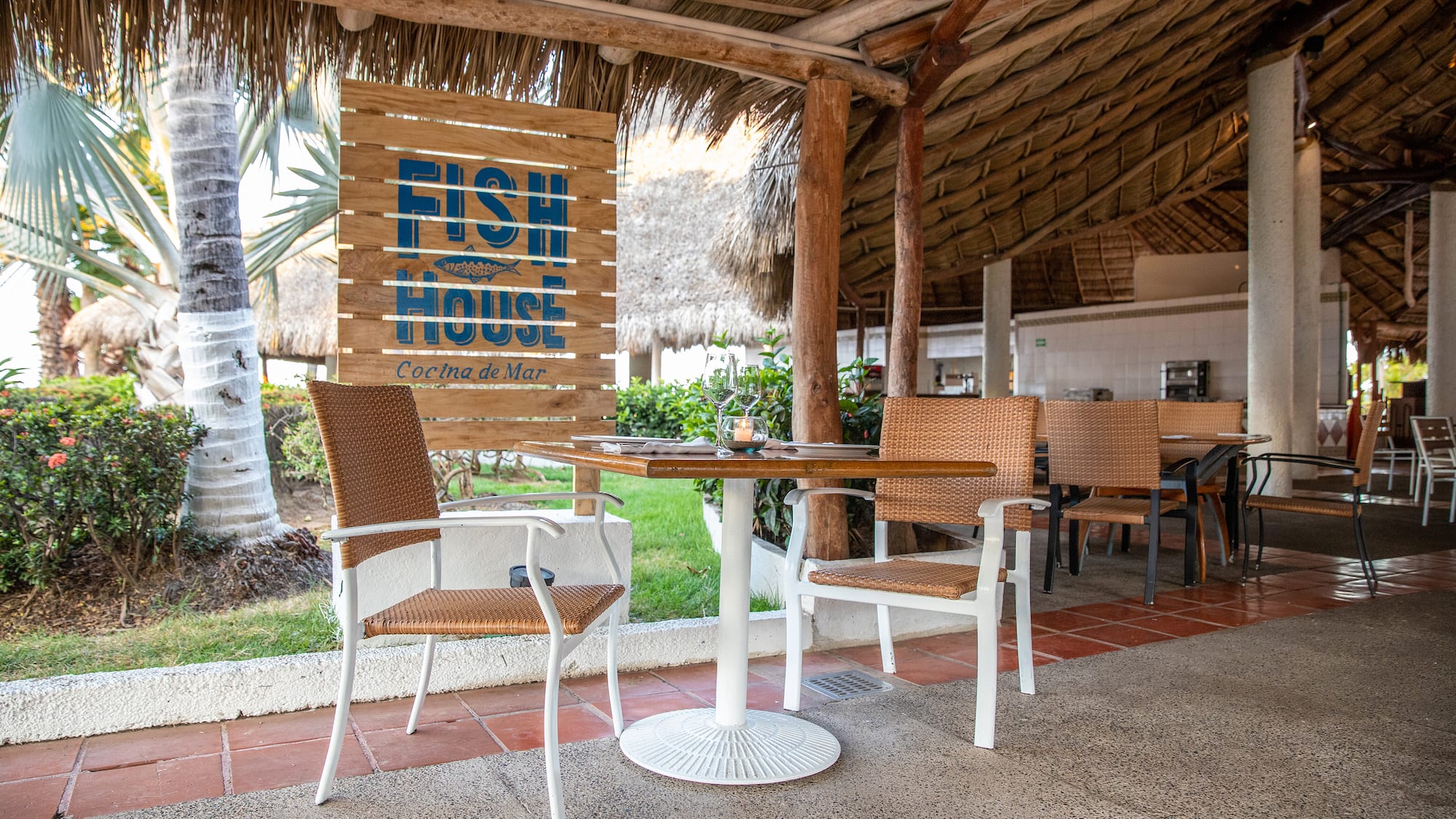 a table and chairs under a thatched roof