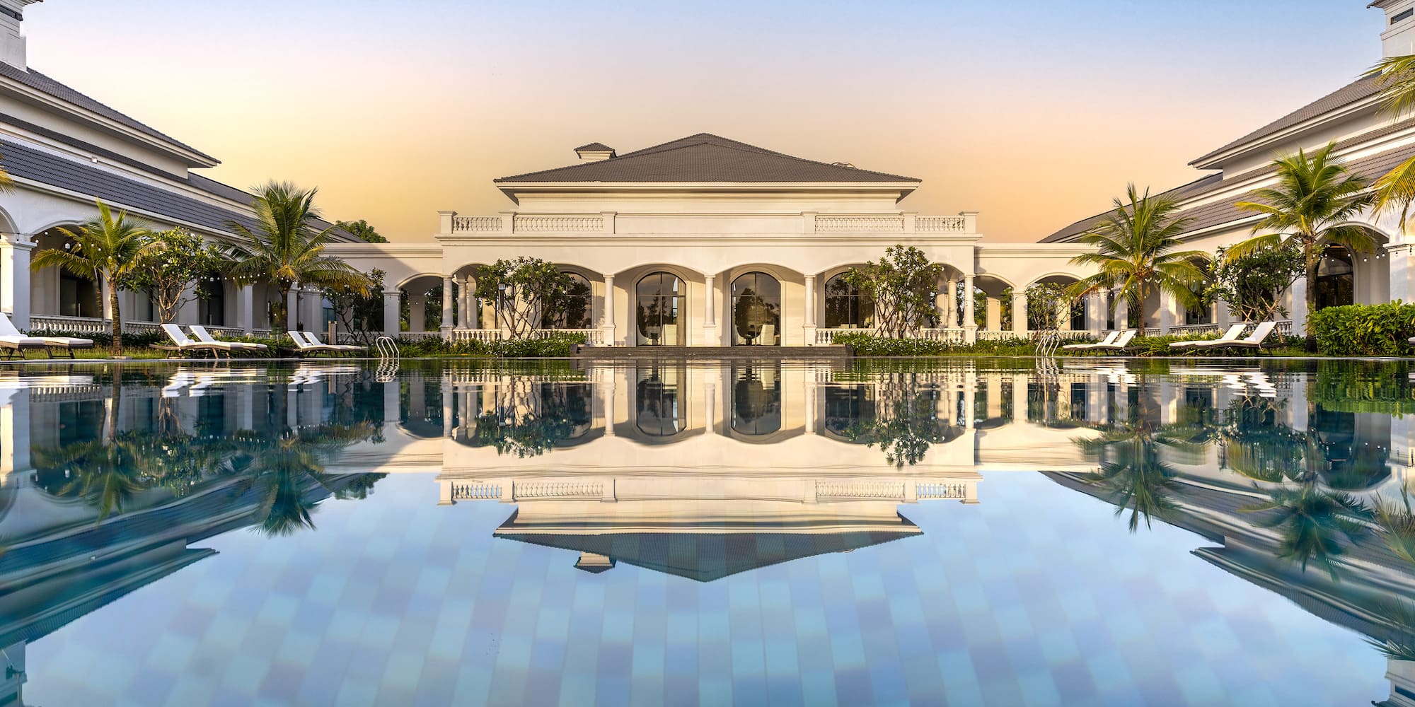 a pool with a building and palm trees
