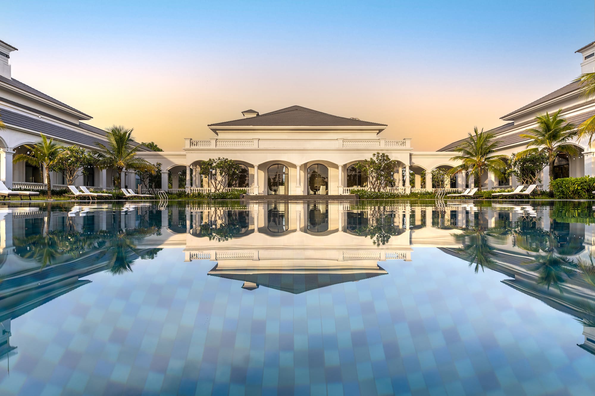a pool with a building and palm trees