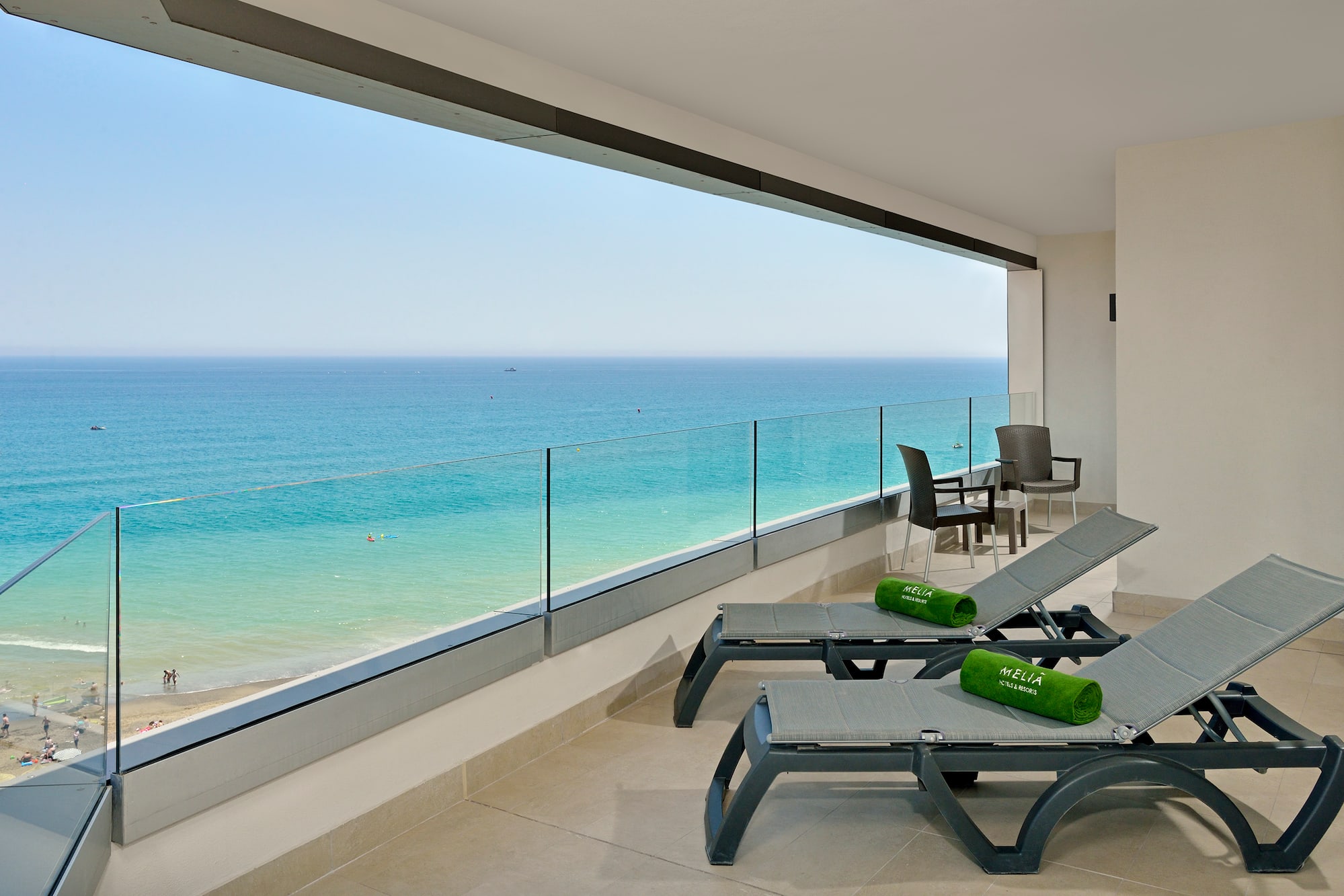 a deck with chairs and a view of the ocean