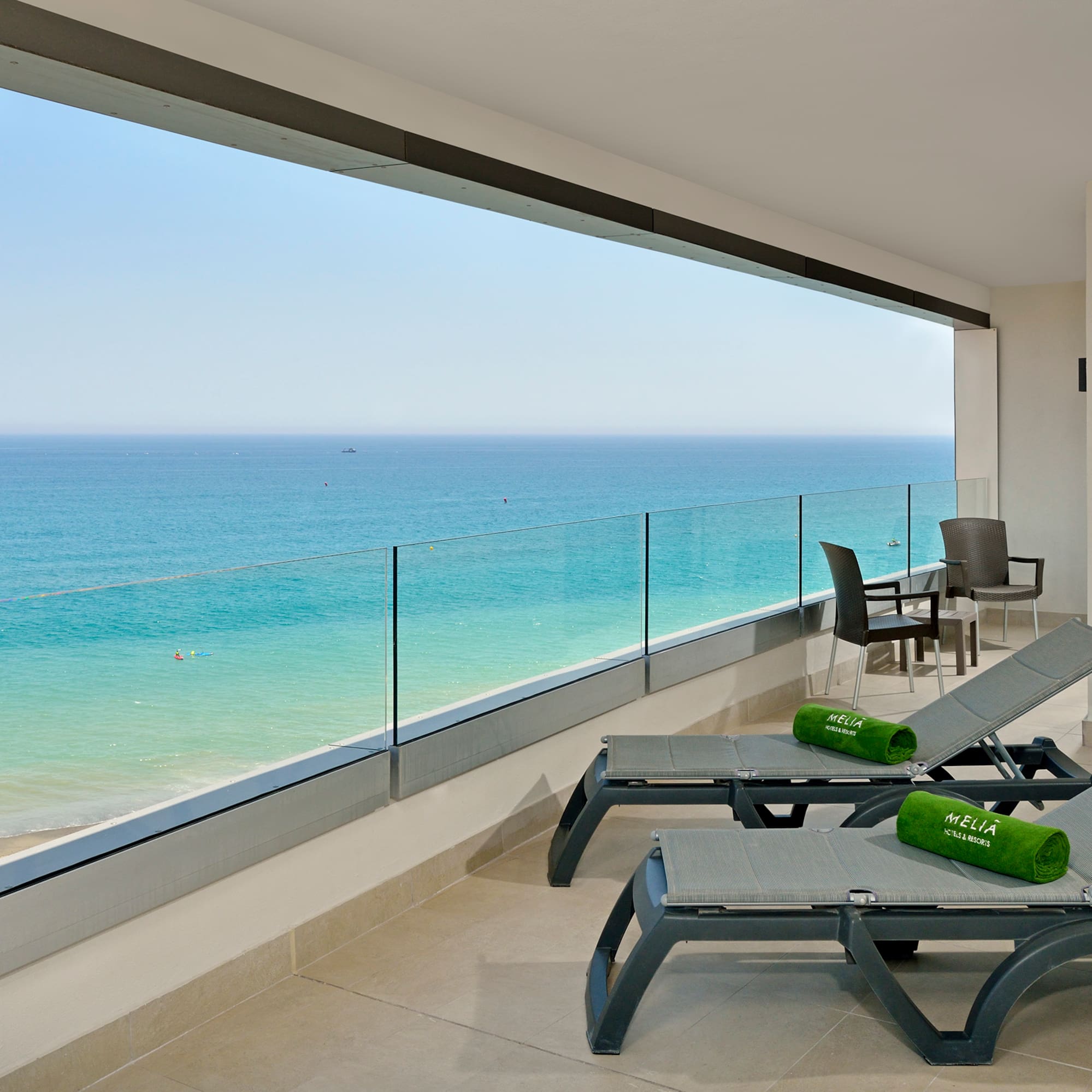a deck with chairs and a view of the ocean