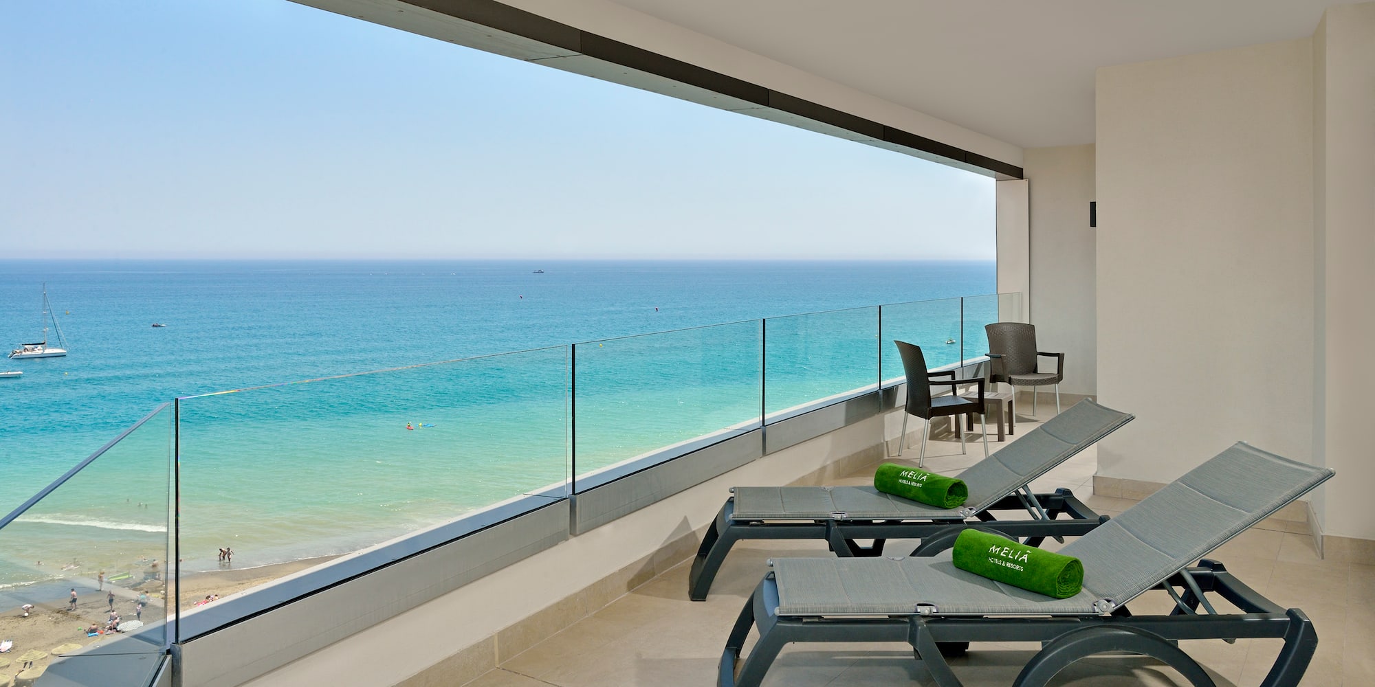 a deck with chairs and a view of the ocean