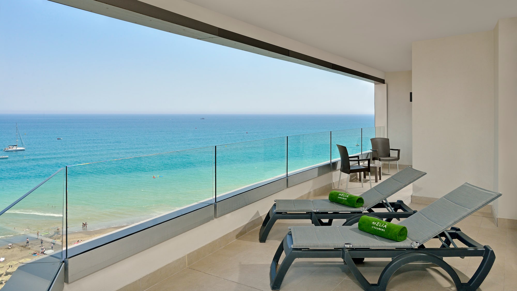 a deck with chairs and a view of the ocean