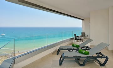 a deck with chairs and a view of the ocean