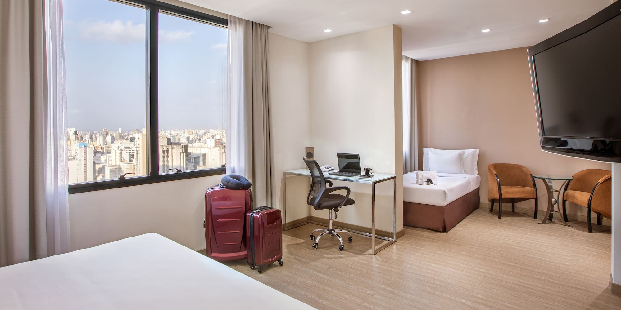 a room with two beds and a desk and chairs