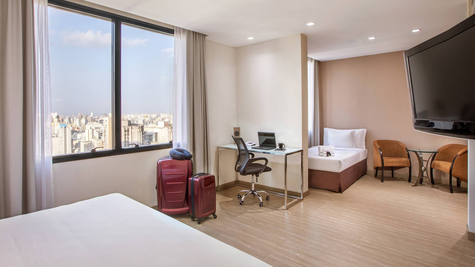 a room with two beds and a desk and chairs