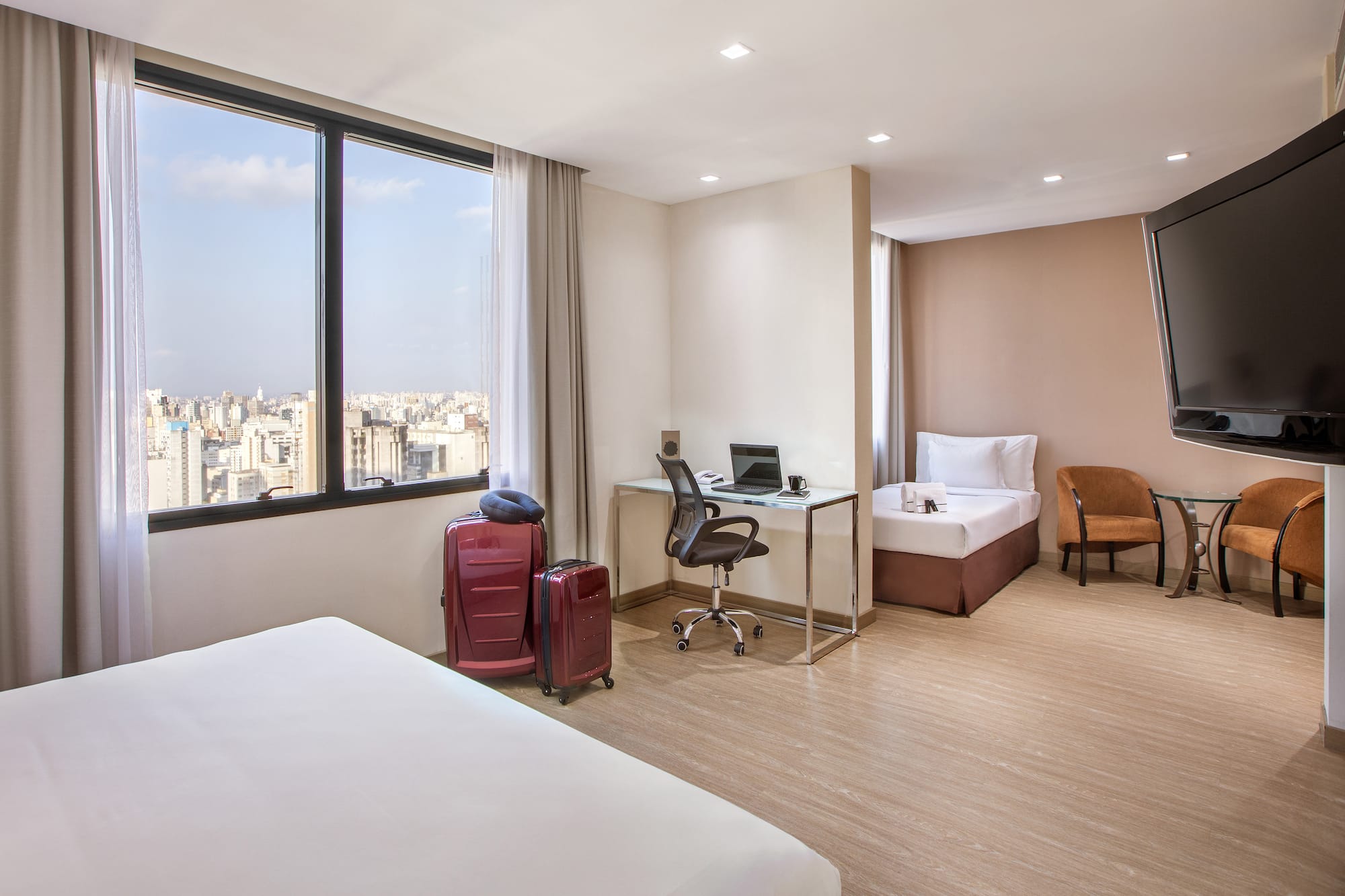 a room with two beds and a desk and chairs