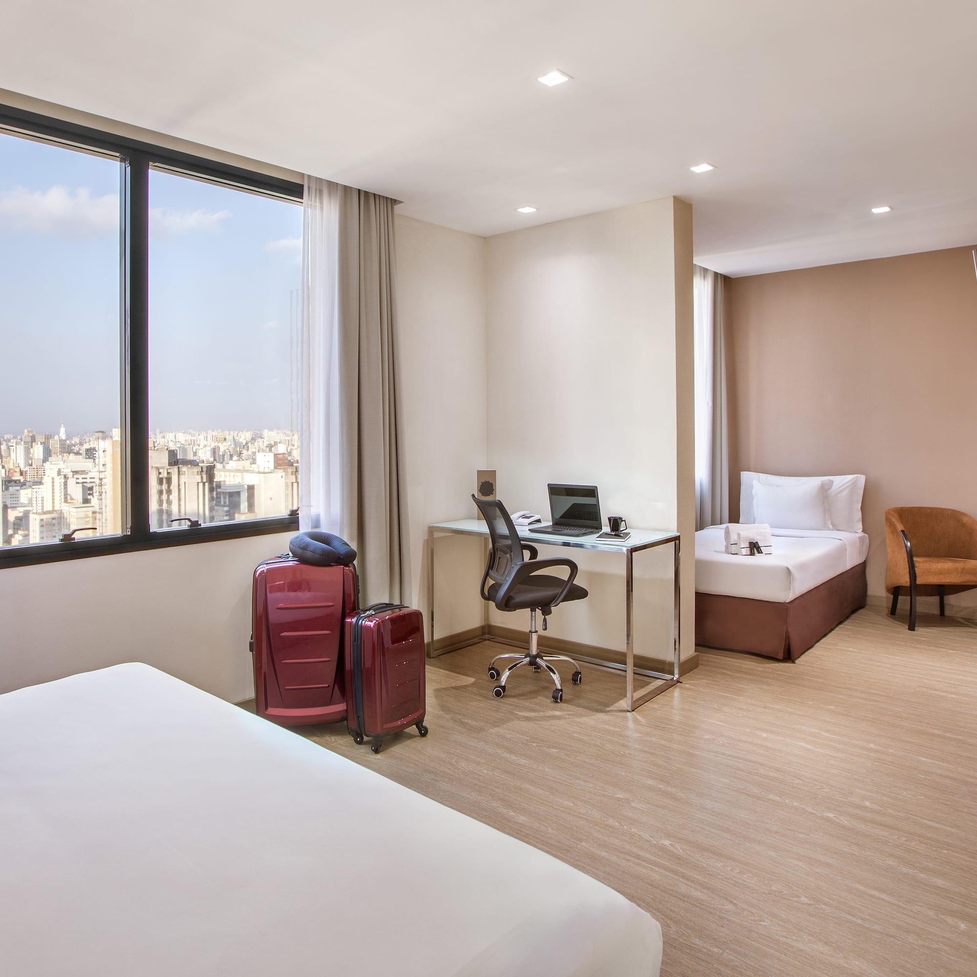 a room with two beds and a desk and chairs