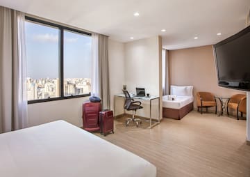 a room with two beds and a desk and chairs