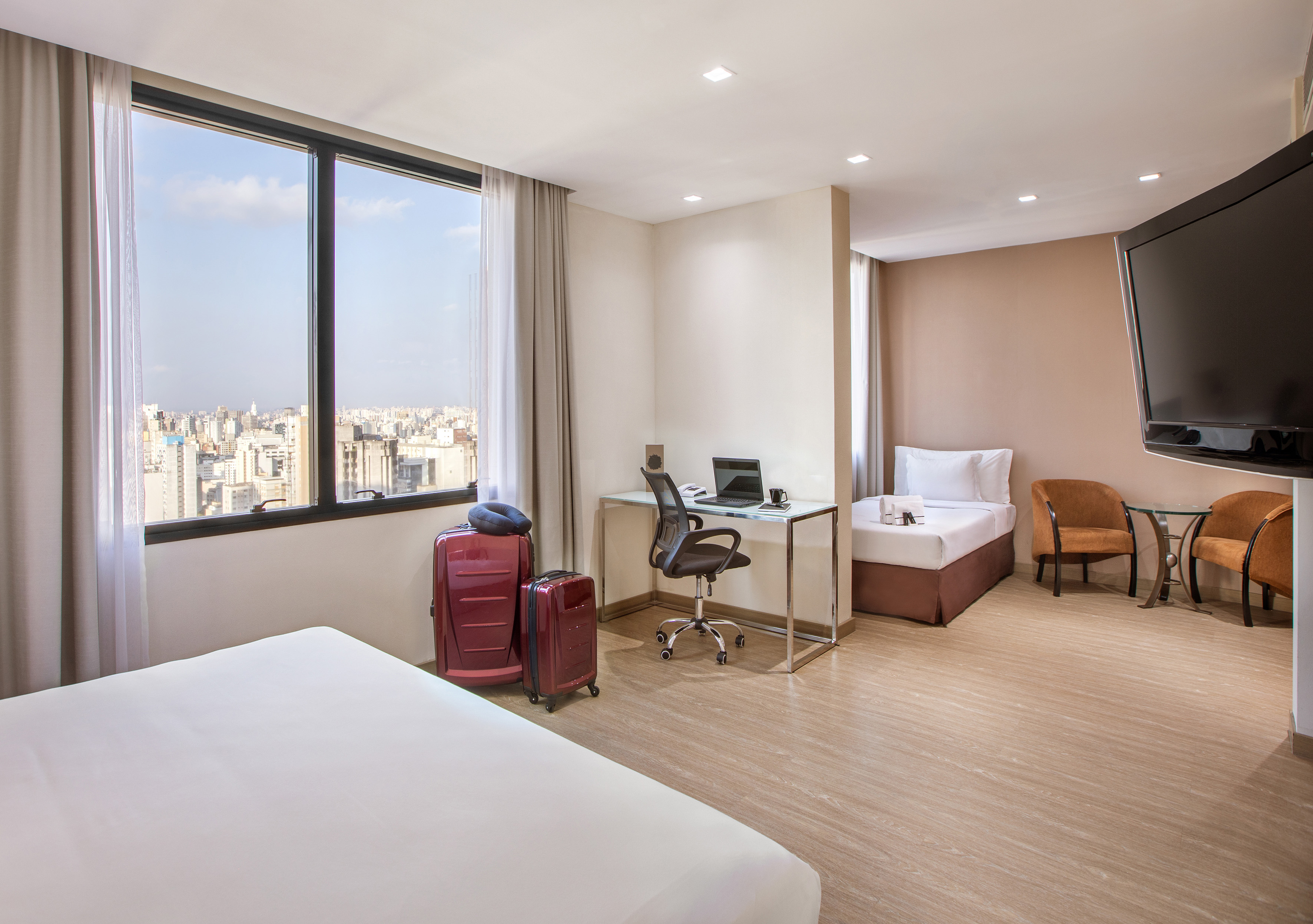 a room with two beds and a desk and chairs