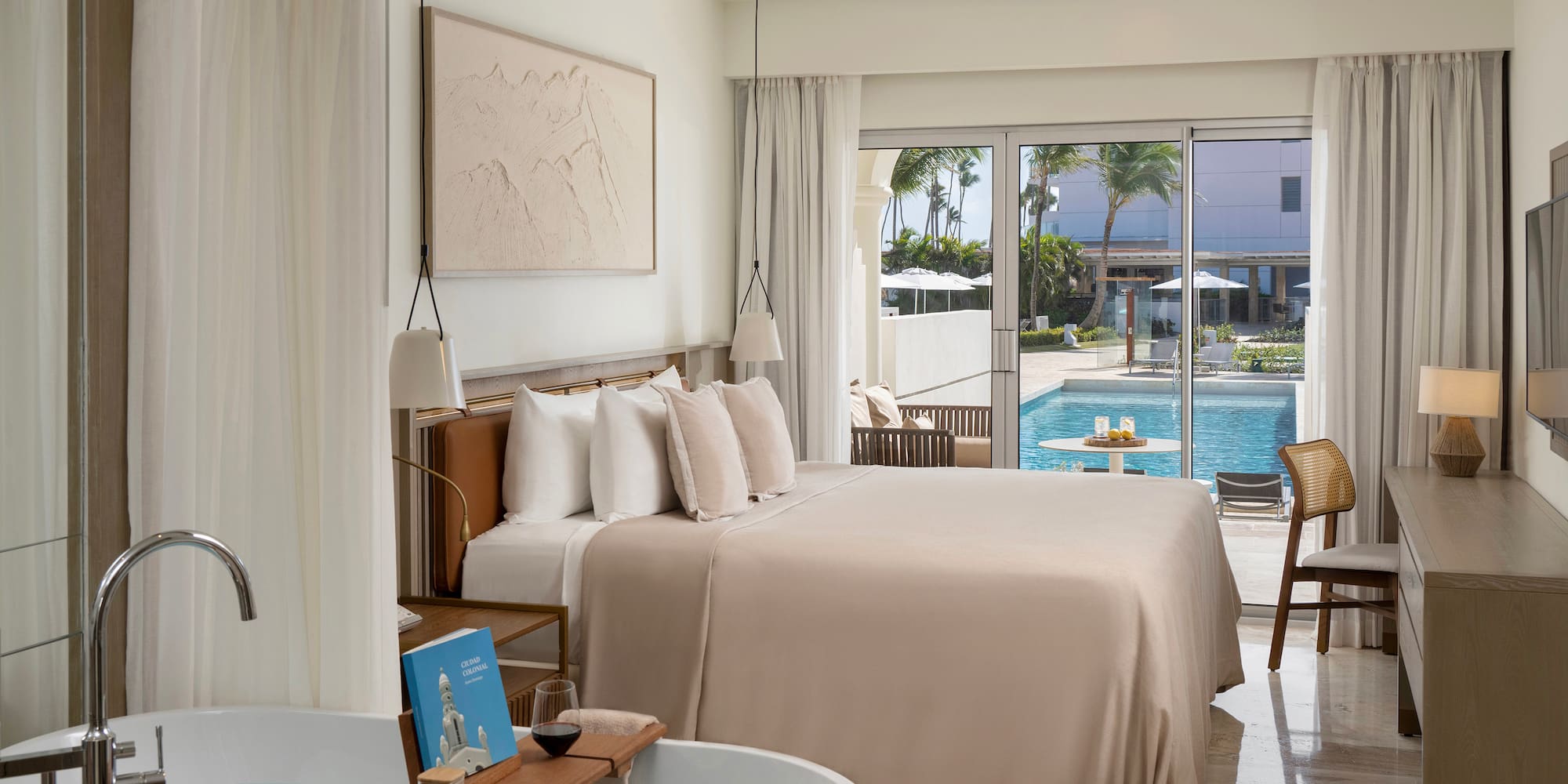 a room with a bed and tub and a pool