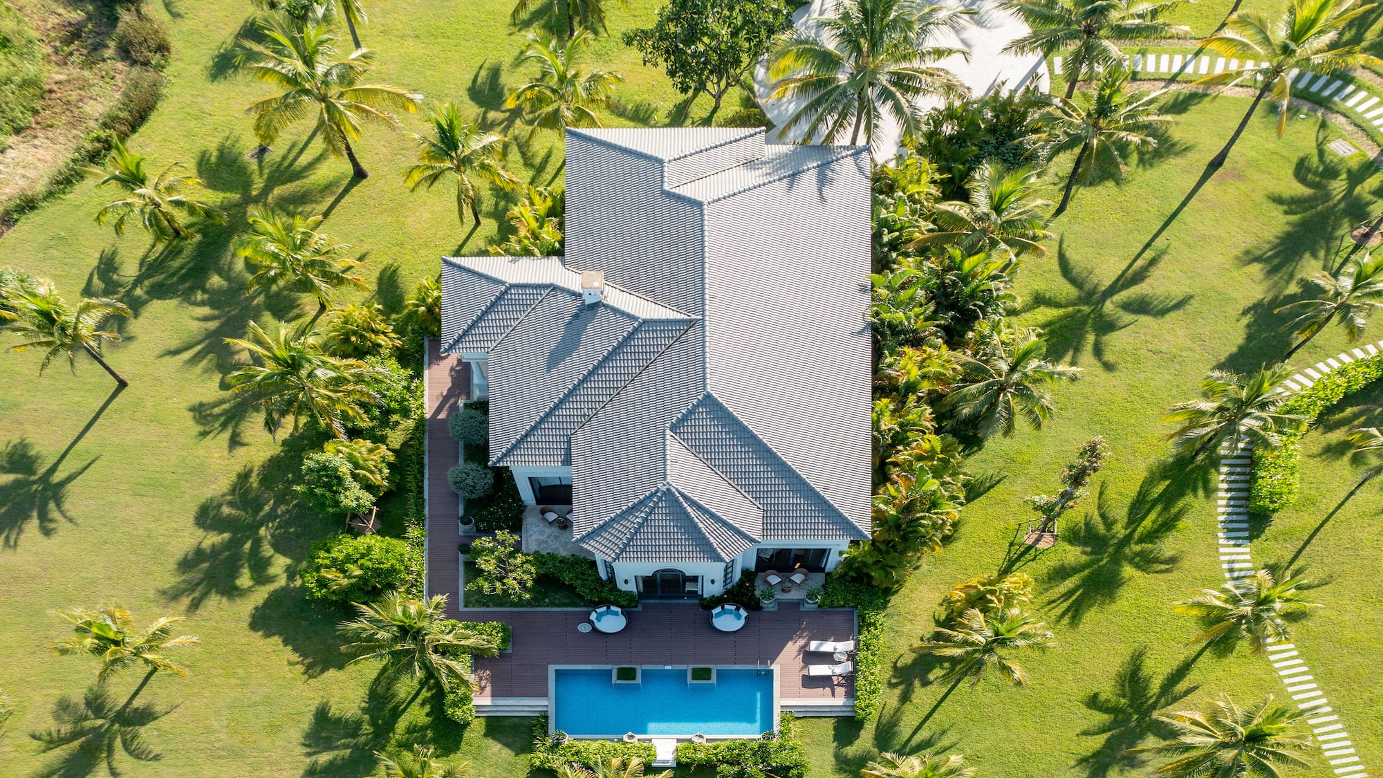 a house with a pool surrounded by palm trees