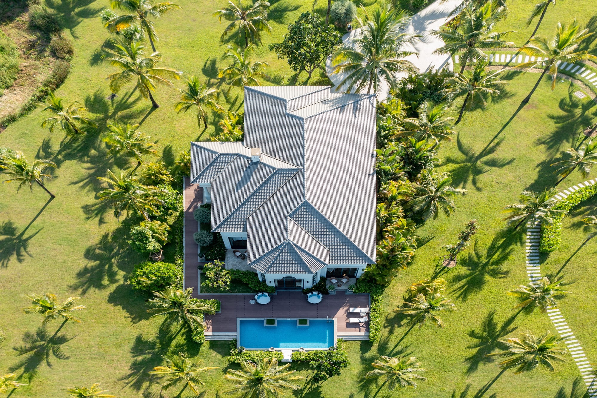 a house with a pool surrounded by palm trees