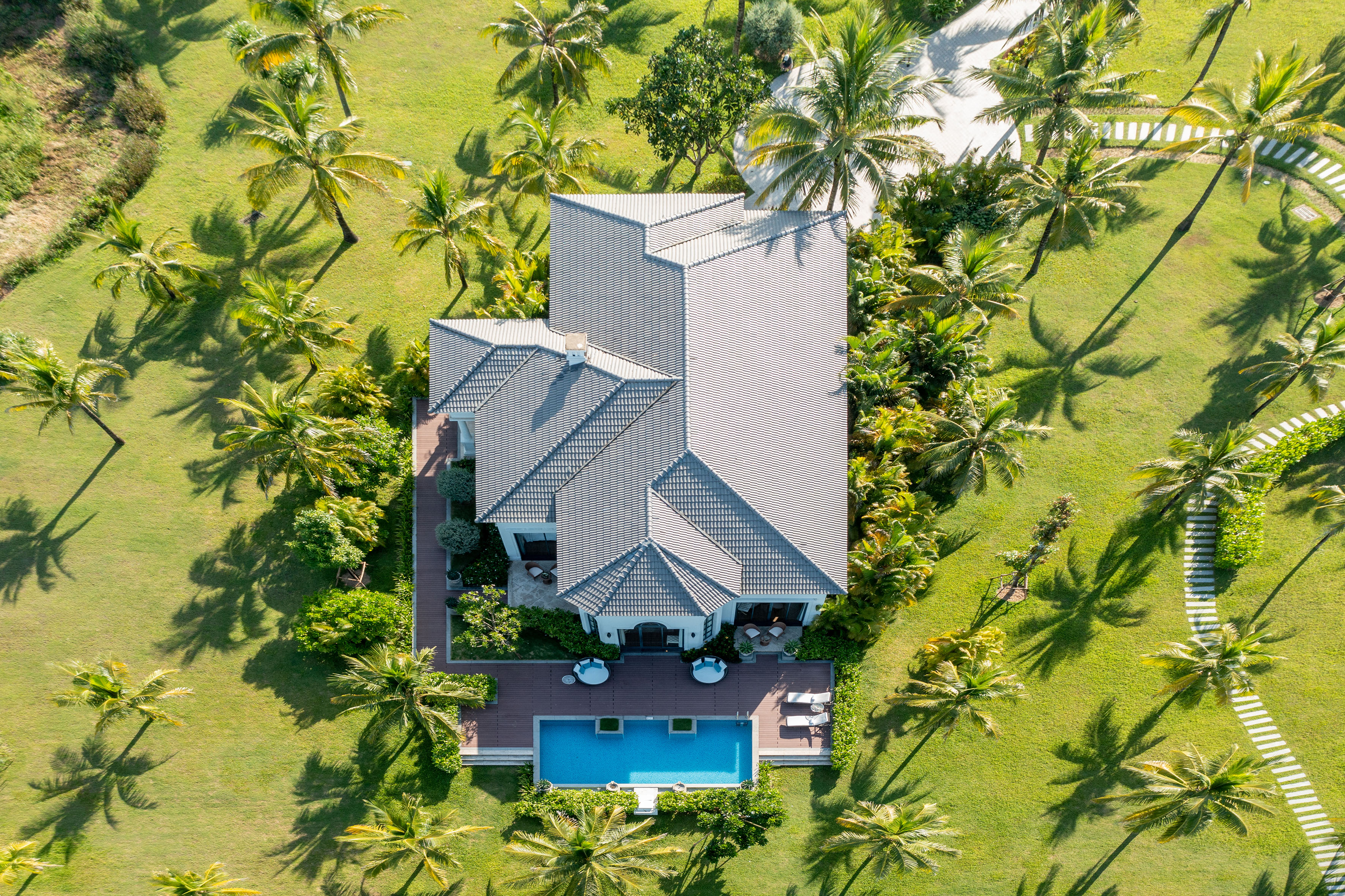a house with a pool surrounded by palm trees