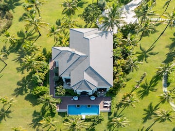 a house with a pool surrounded by palm trees