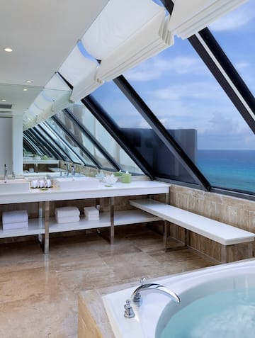 a bathroom with a large window overlooking the ocean