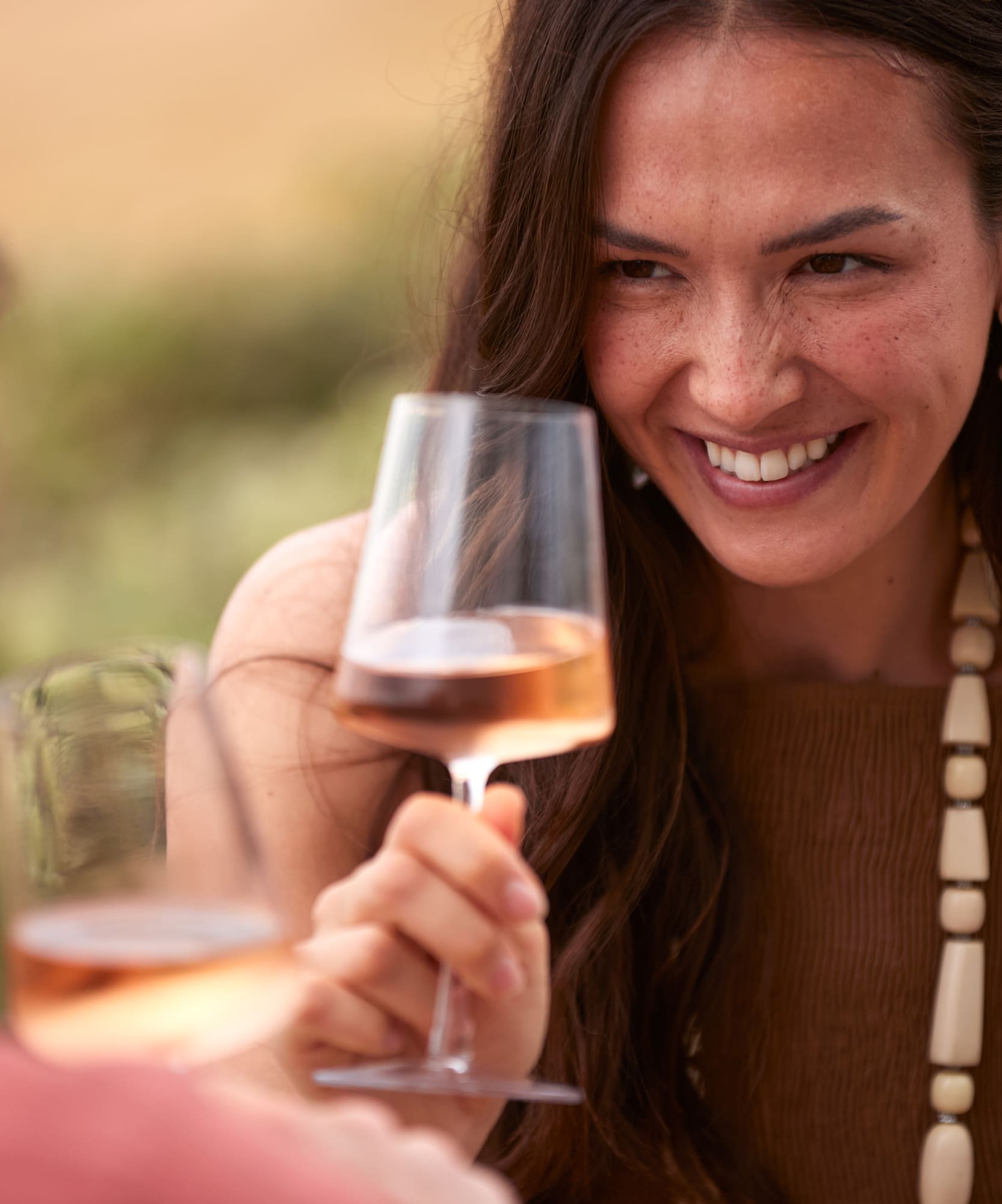 a woman holding a wine glass with a man in the background