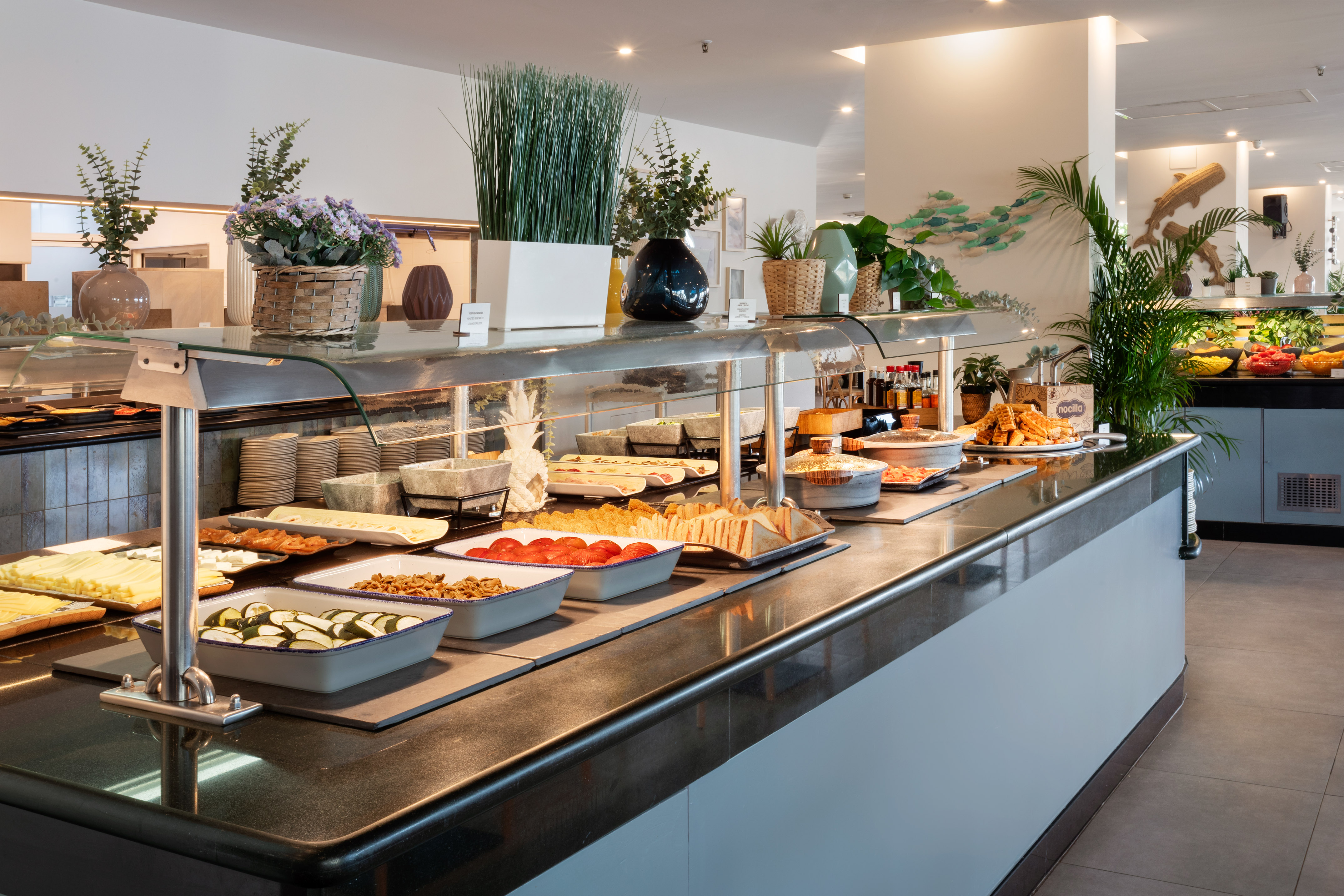 Modern hotel breakfast buffet featuring a variety of hot and cold dishes.