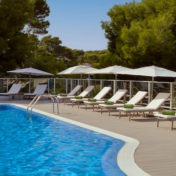 a pool with chairs and umbrellas