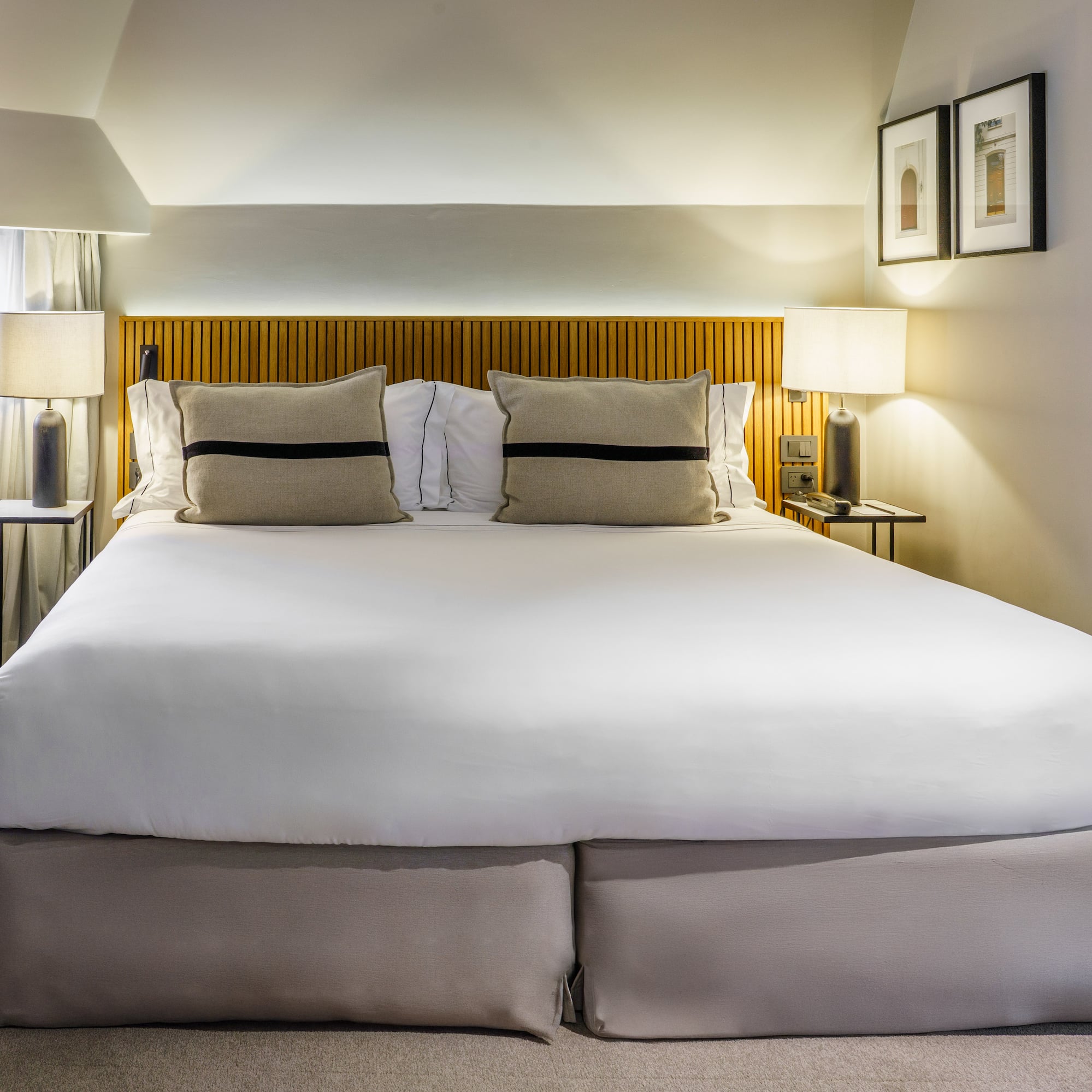 a bed with white sheets and pillows