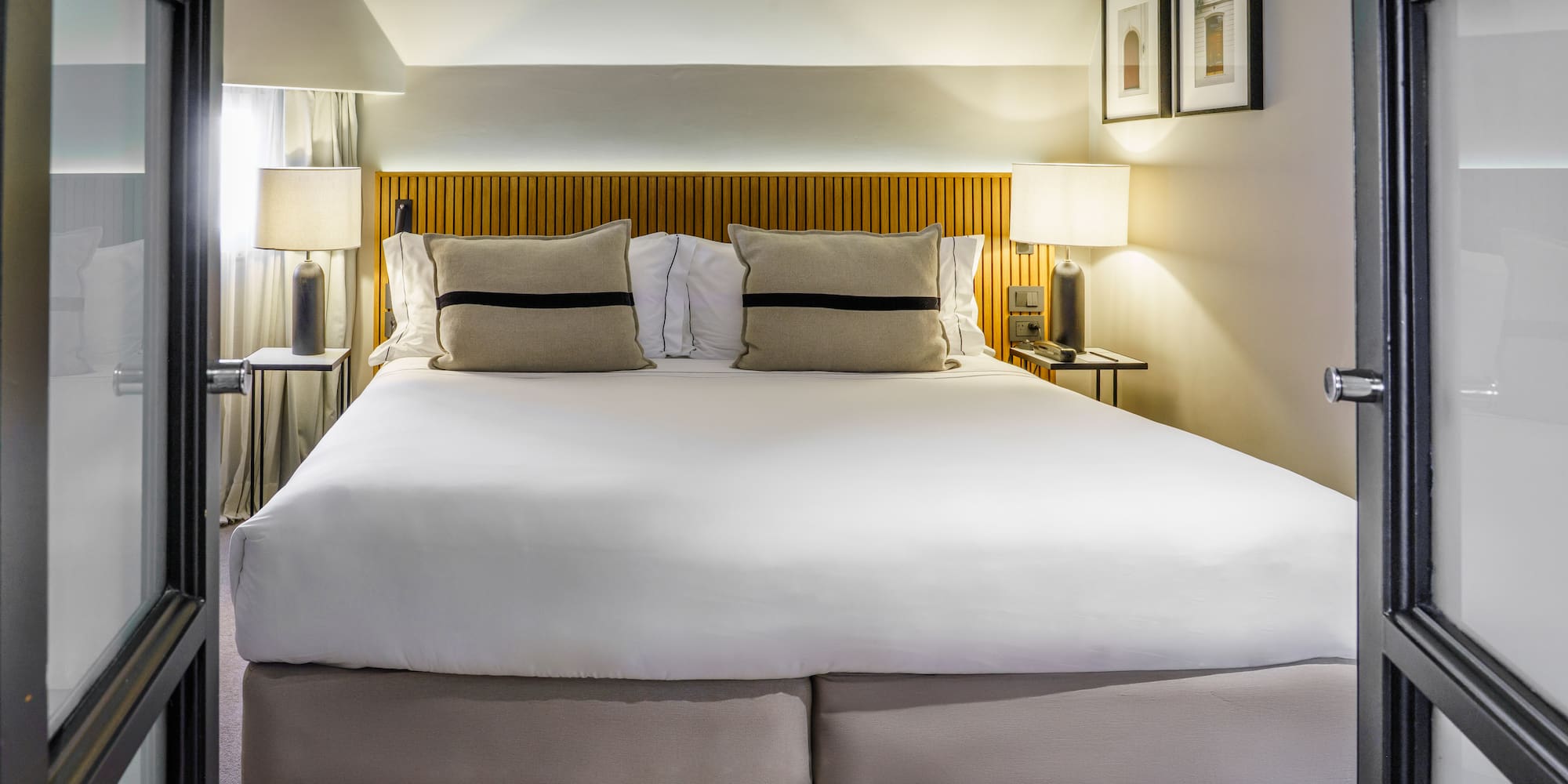 a bed with white sheets and pillows