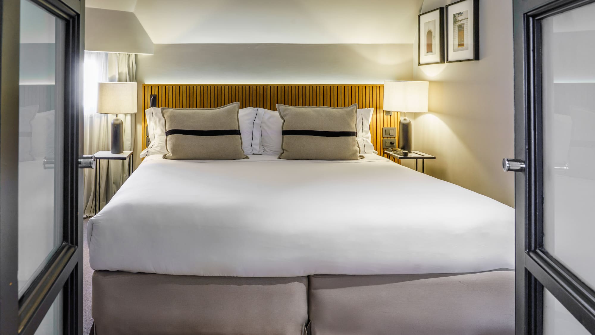 a bed with white sheets and pillows