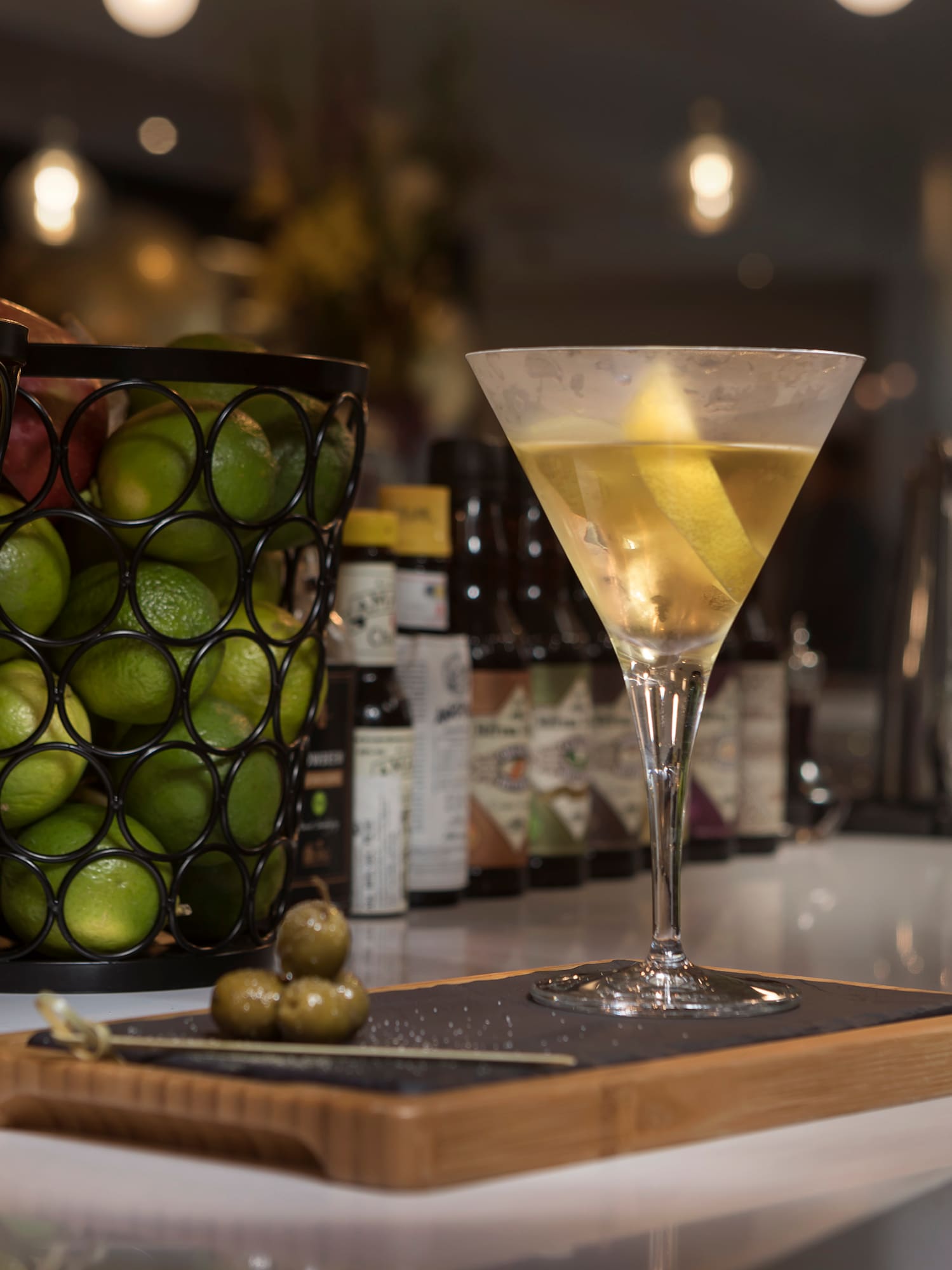 a glass of liquid next to a tray of fruit