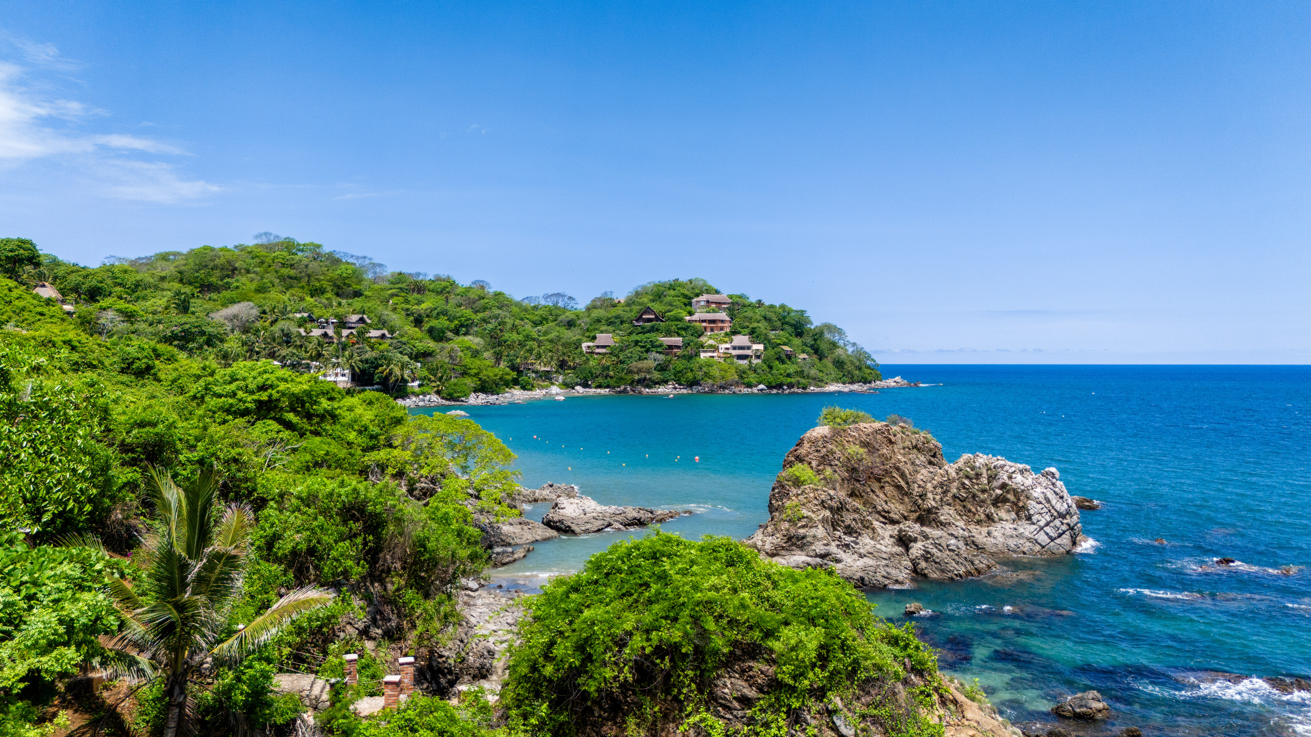 a body of water with trees and houses on a hill