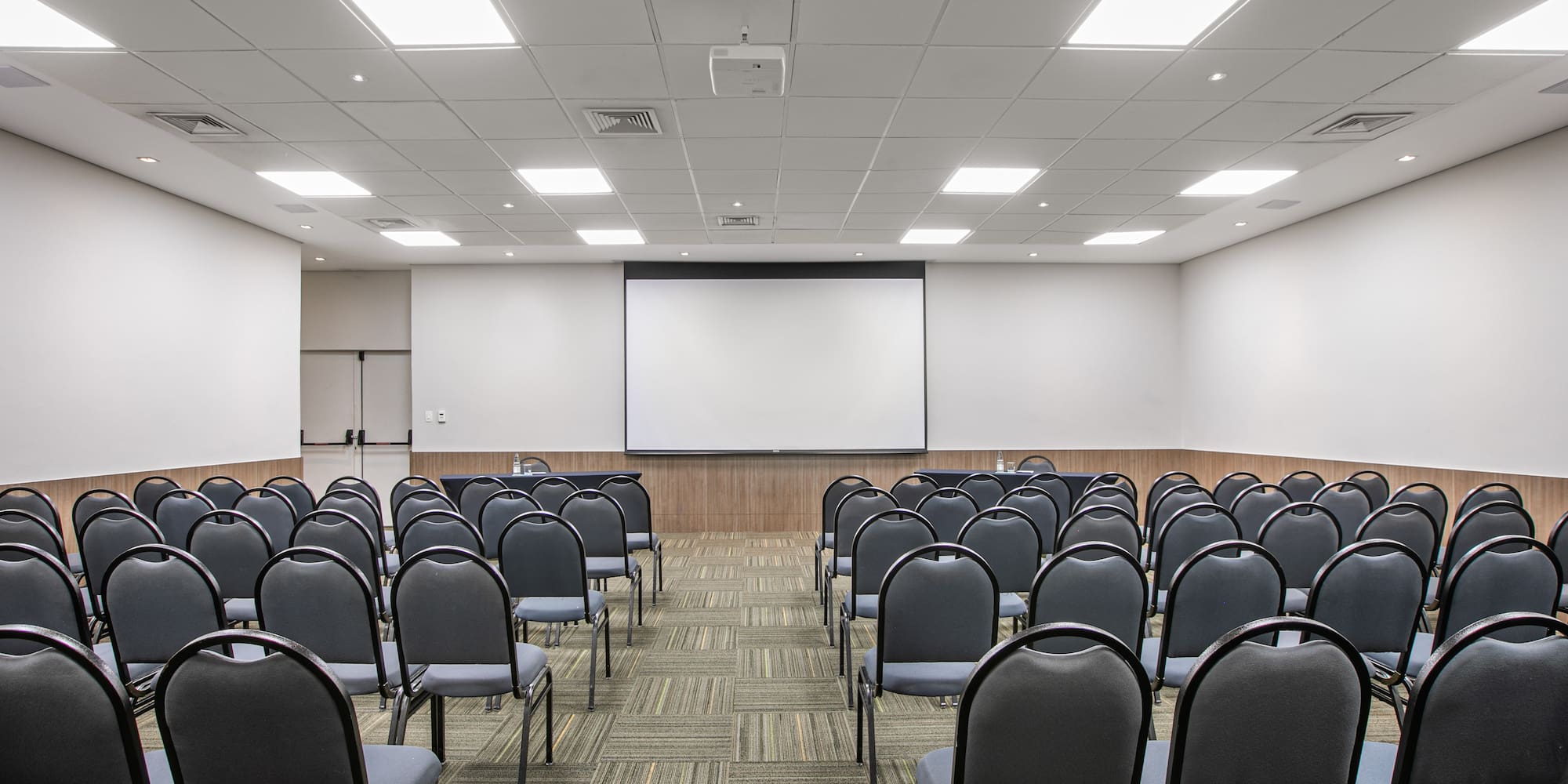 a room with chairs and a projector screen