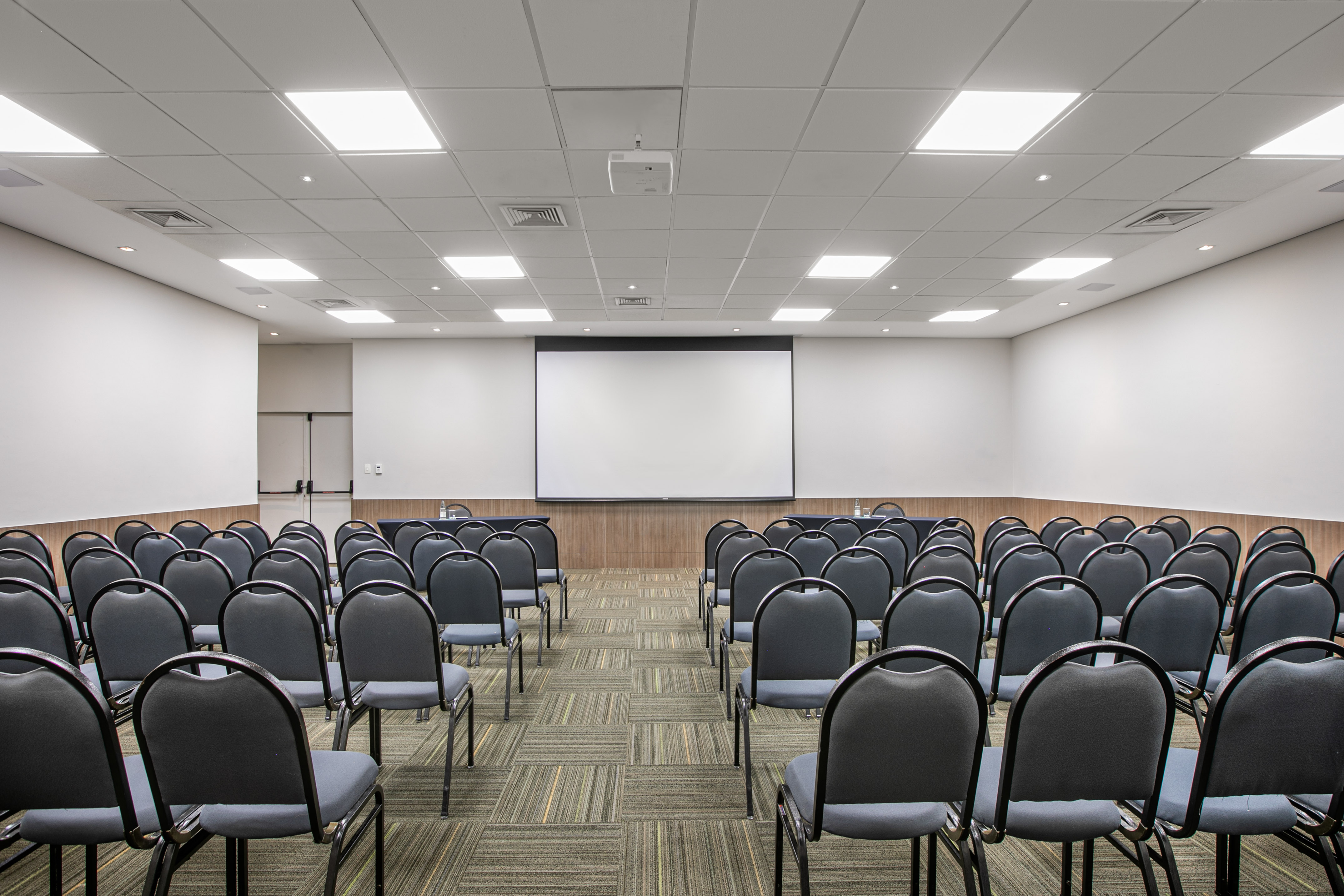 a room with chairs and a projector screen