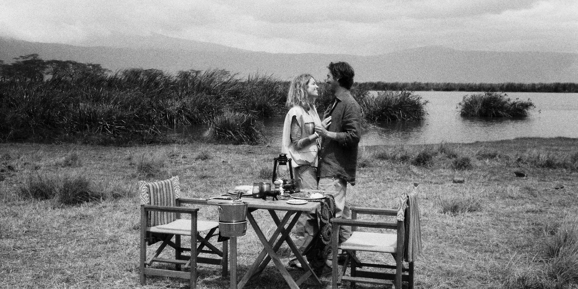 a man and woman standing next to a table