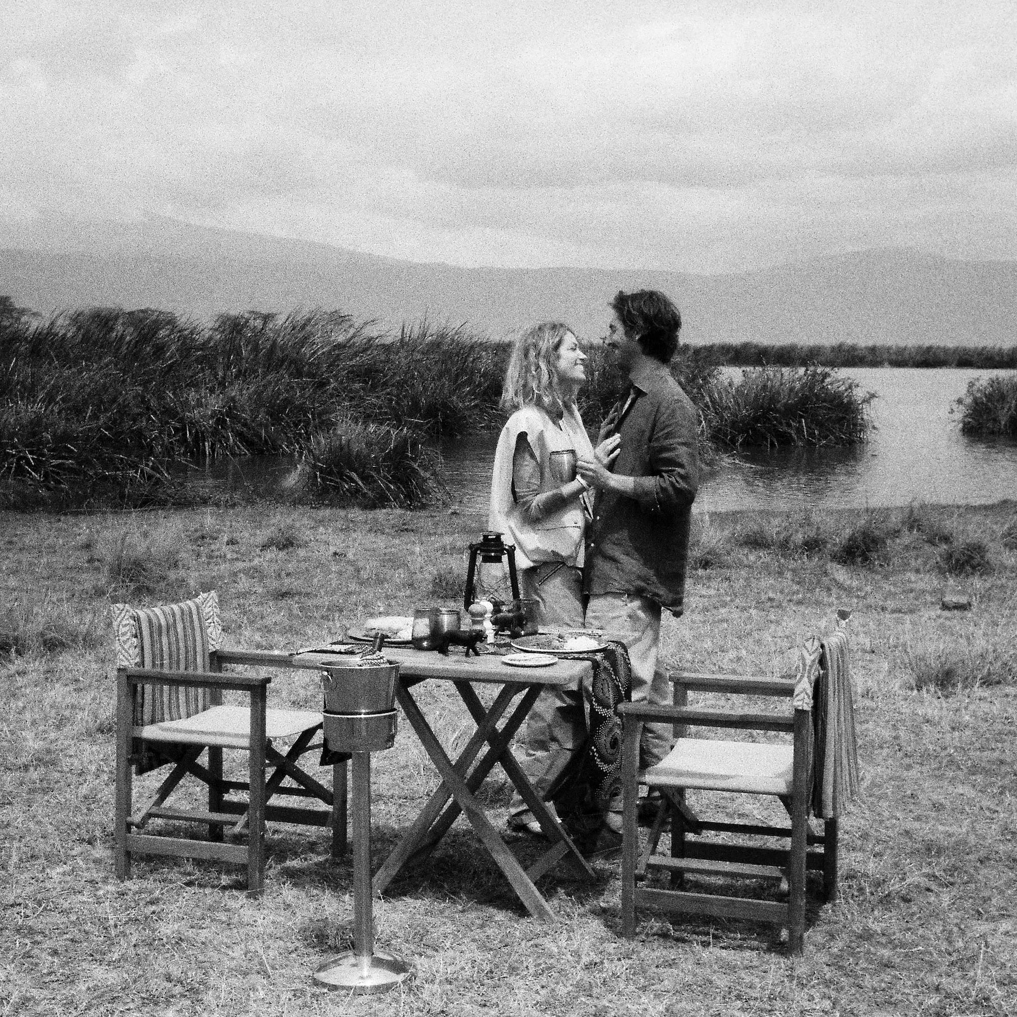 a man and woman standing next to a table