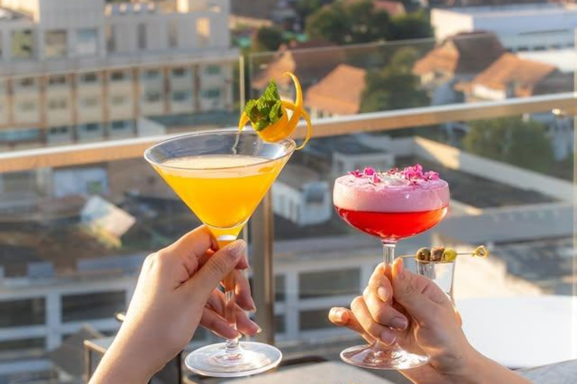 Rooftop cocktails and appetizers with city skyline view.